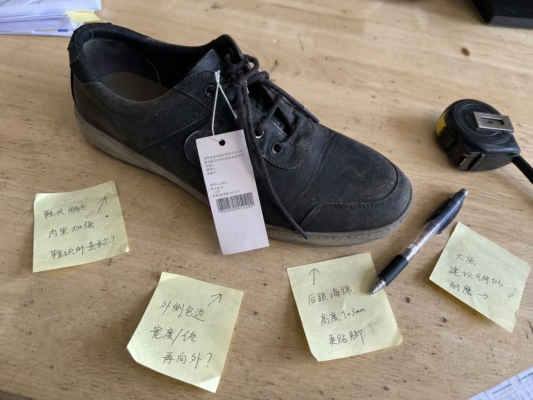 一只买回来的样鞋还挂着吊牌,旁边贴着几张手写改款批注便签